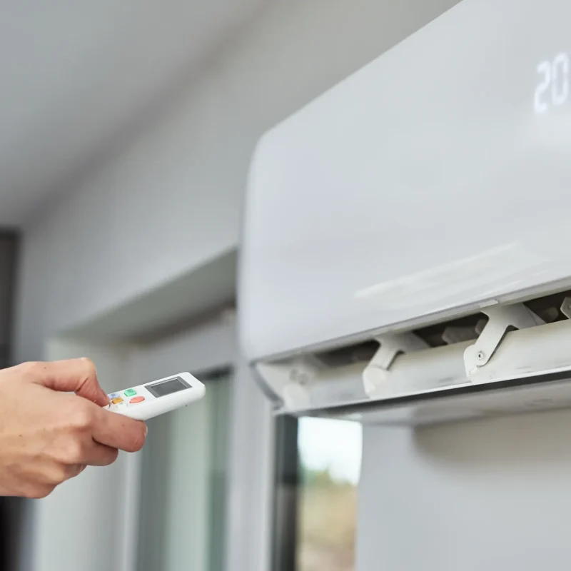 hand-adjusting-temperature-on-air-conditioner-2023-11-27-05-32-49-utc